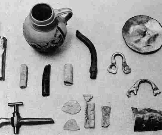 [Illustration: Lead and copper pipes, kettle fragments, a brass spigot, and other items found which may have been used for brewing or distilling purposes.]