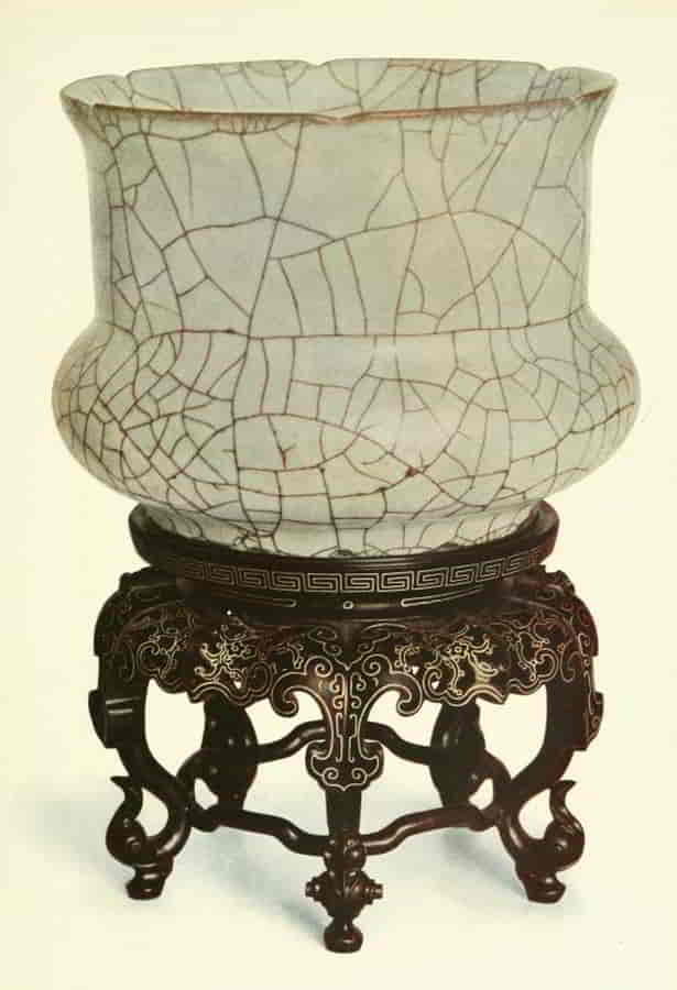 Wide rimmed bowl sitting on decorated stand