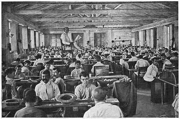 De arbeiders in de sigarenfabriek worden onder het werk voorgelezen.