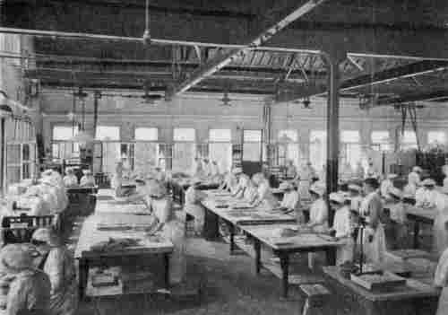 A CONFECTIONERY ROOM AT MESSRS. CADBURY'S WORKS AT BOURNVILLE. Cutting almond paste by hand moulds.